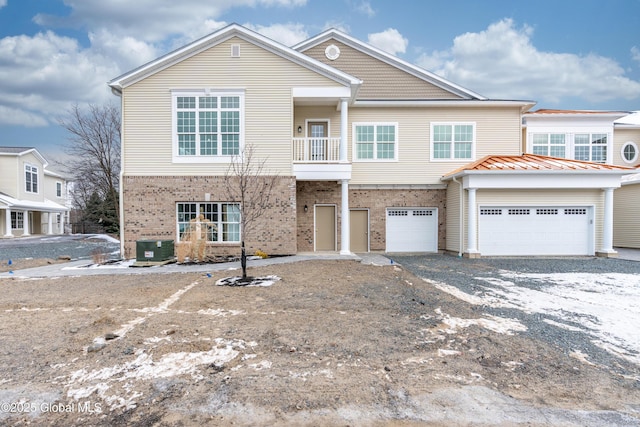 view of front of property with central AC, a balcony, and a garage