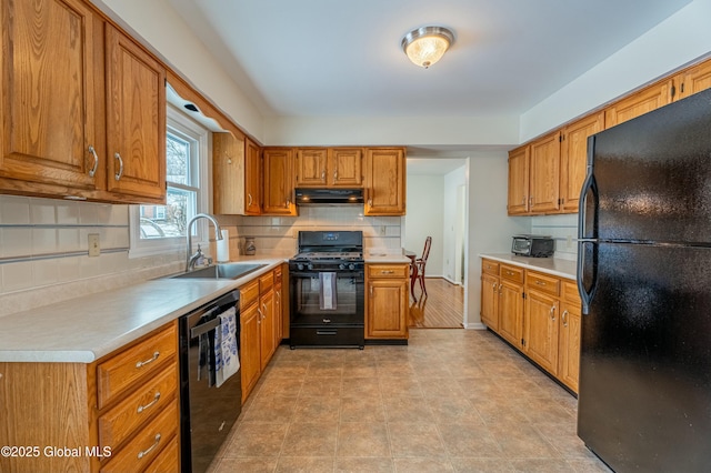 kitchen with black appliances, decorative backsplash, and sink