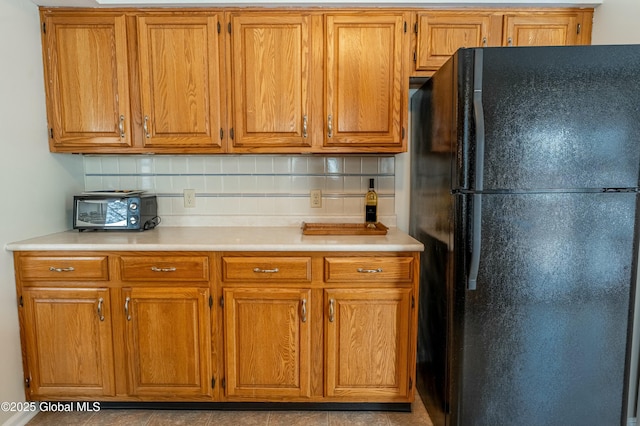 kitchen with black fridge and tasteful backsplash