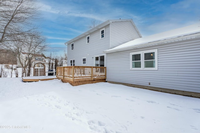 snow covered house featuring a deck