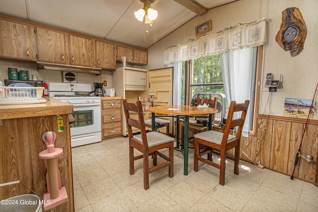 kitchen with vaulted ceiling with beams, wooden walls, and white gas range oven