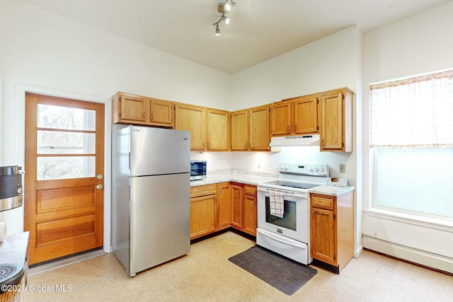 kitchen with appliances with stainless steel finishes, a healthy amount of sunlight, and track lighting