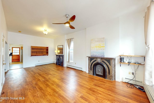 unfurnished living room featuring hardwood / wood-style flooring, a baseboard radiator, and ceiling fan