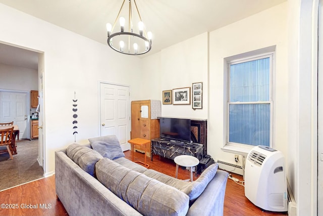 living room featuring hardwood / wood-style floors, a chandelier, and a baseboard heating unit