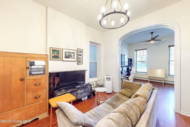 living room with dark wood-type flooring, a baseboard radiator, and ceiling fan with notable chandelier