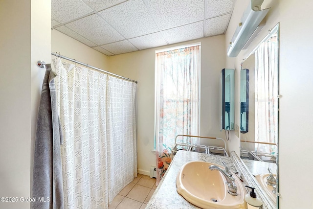 bathroom featuring a paneled ceiling, tile patterned floors, a baseboard radiator, and vanity