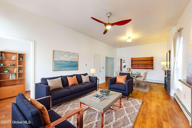 living room featuring ceiling fan, light hardwood / wood-style flooring, and a baseboard heating unit