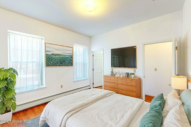 bedroom with a baseboard radiator and hardwood / wood-style floors