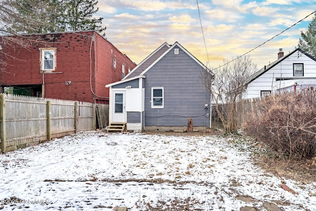 view of snow covered back of property