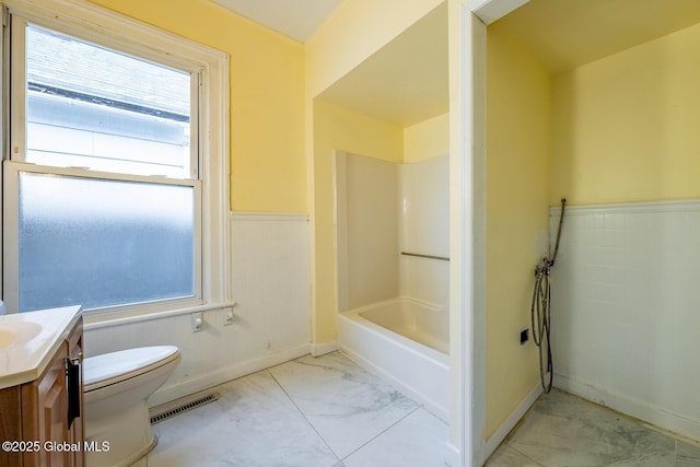 bathroom with plenty of natural light, toilet, and vanity