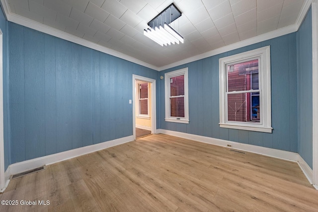 empty room with light wood-type flooring and ornamental molding