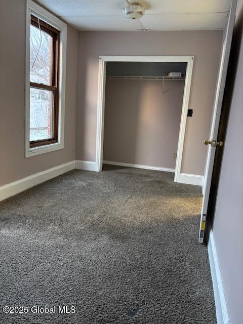 unfurnished bedroom with carpet and a closet