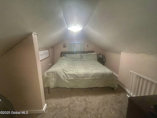 carpeted bedroom with radiator heating unit and vaulted ceiling