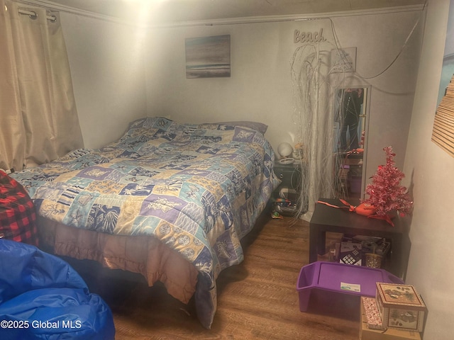 bedroom with hardwood / wood-style flooring and ornamental molding