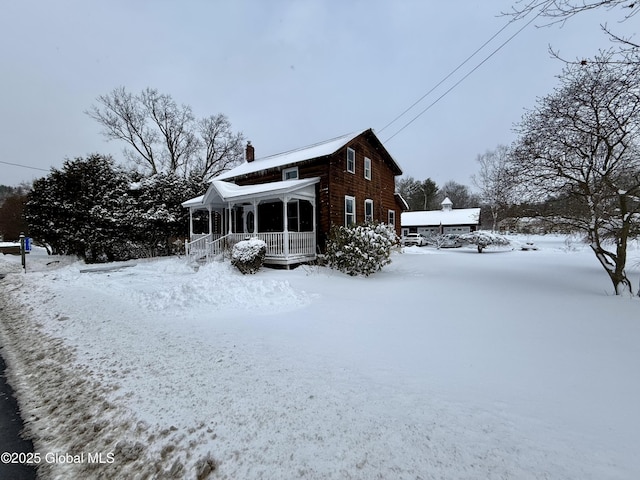 view of snowy exterior featuring covered porch