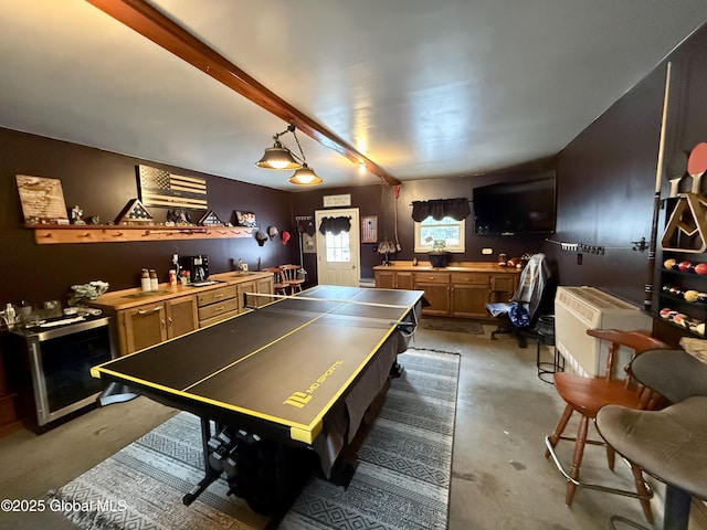 rec room featuring beamed ceiling, concrete floors, and wine cooler