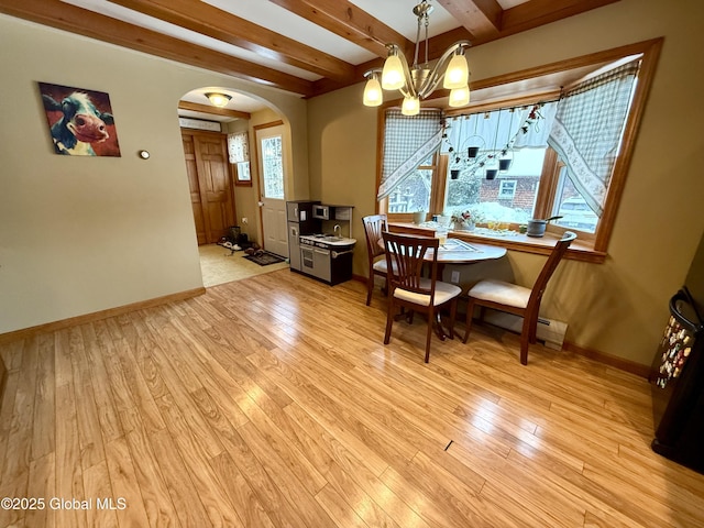 dining area featuring beamed ceiling, light hardwood / wood-style floors, and an inviting chandelier