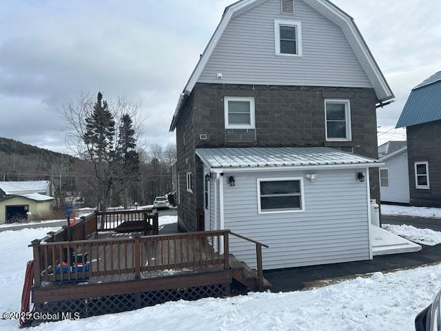 snow covered property with a wooden deck