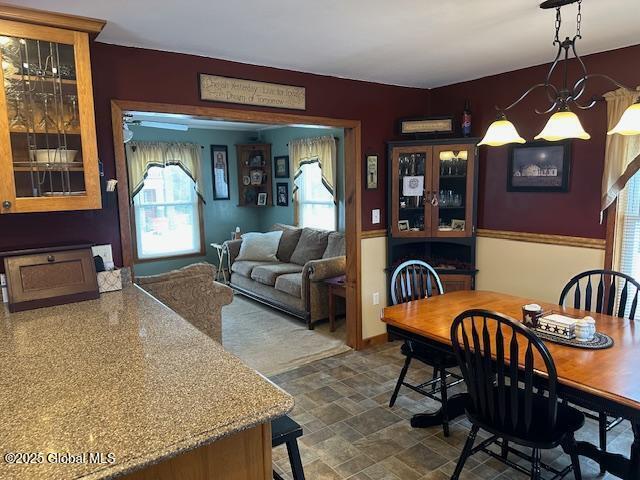 dining area with ceiling fan with notable chandelier