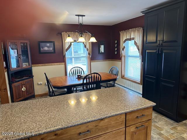 kitchen with light stone counters, decorative light fixtures, and a notable chandelier