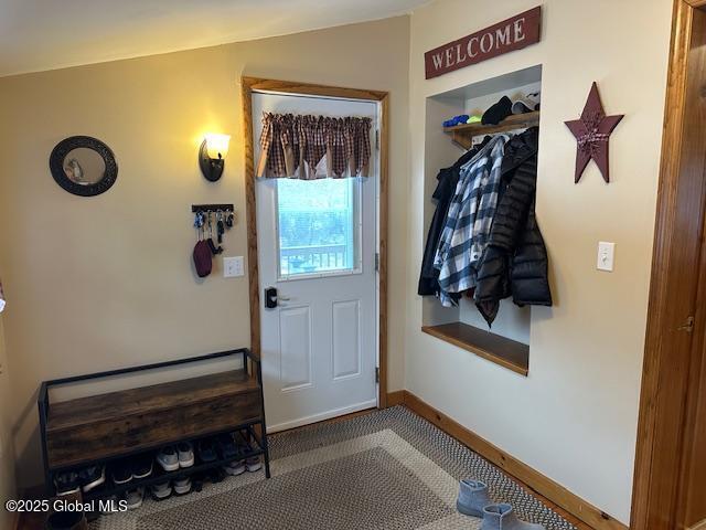 entryway featuring carpet flooring and vaulted ceiling