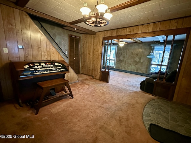 misc room with light carpet, a chandelier, and wood walls