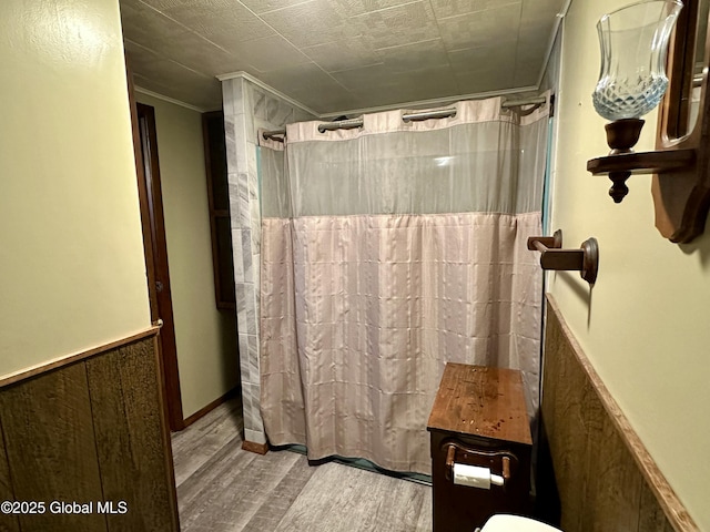 bathroom featuring hardwood / wood-style flooring, crown molding, and walk in shower