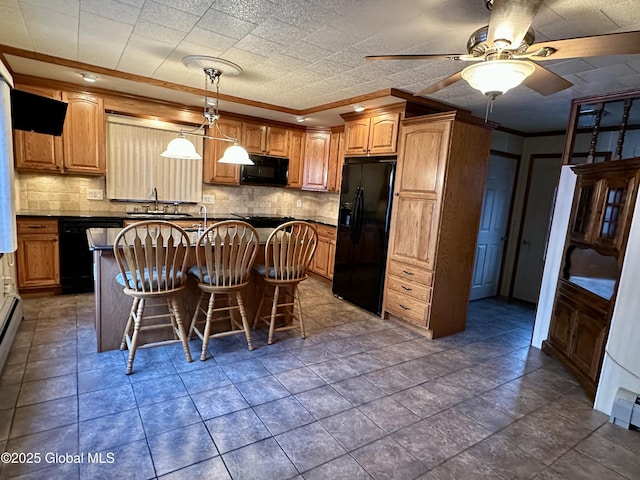 kitchen with tasteful backsplash, a breakfast bar area, black appliances, and a kitchen island