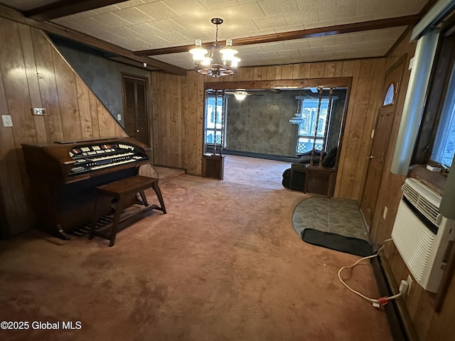 miscellaneous room featuring beam ceiling, a chandelier, carpet, and wood walls