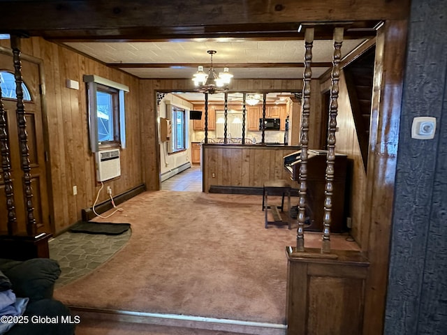 interior space with beamed ceiling, light carpet, wooden walls, and decorative light fixtures