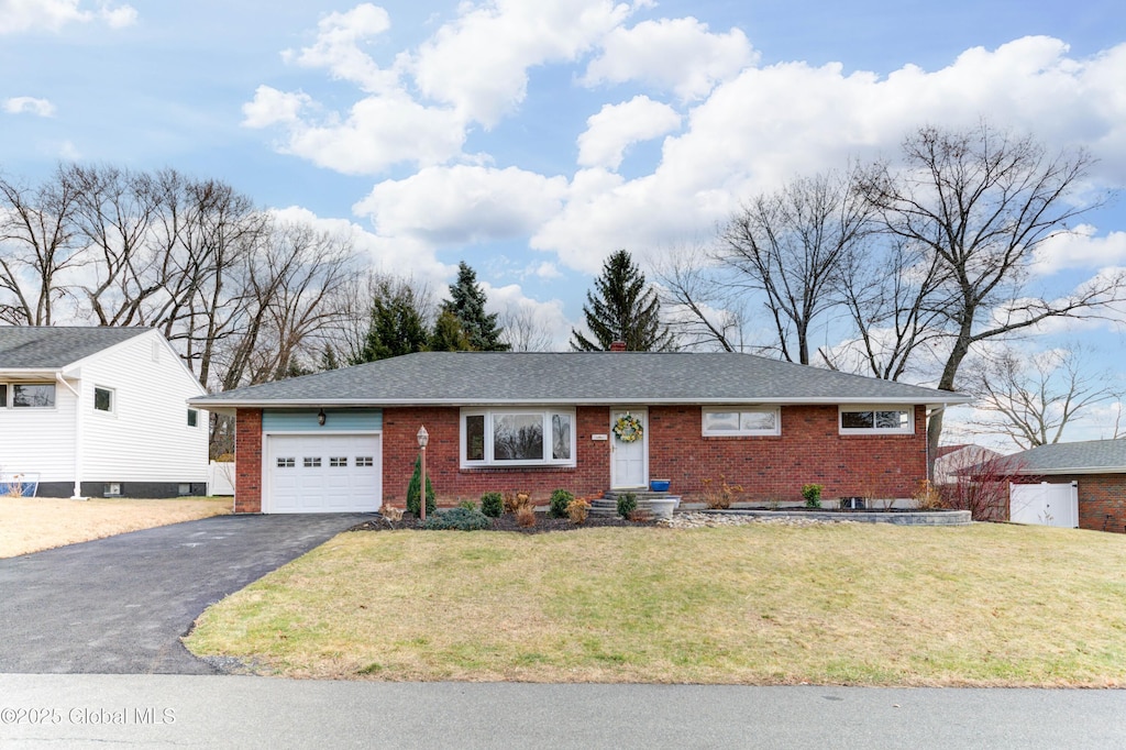 single story home featuring a garage and a front lawn