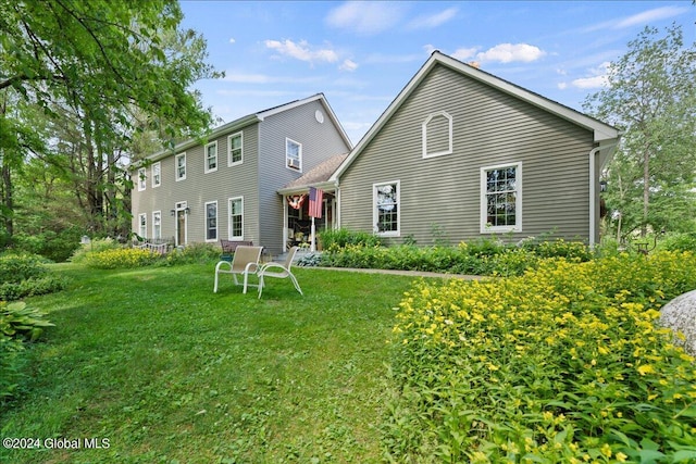 rear view of property featuring a yard