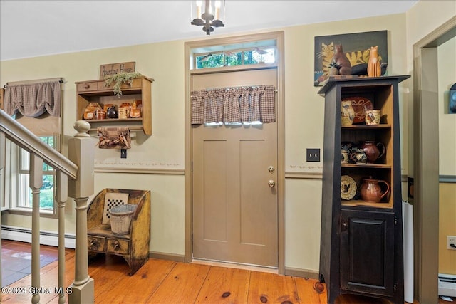 doorway to outside featuring a baseboard radiator and hardwood / wood-style flooring