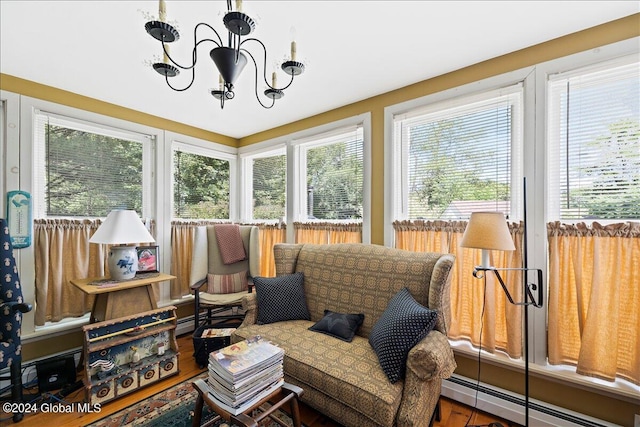 sunroom / solarium with a baseboard heating unit and an inviting chandelier