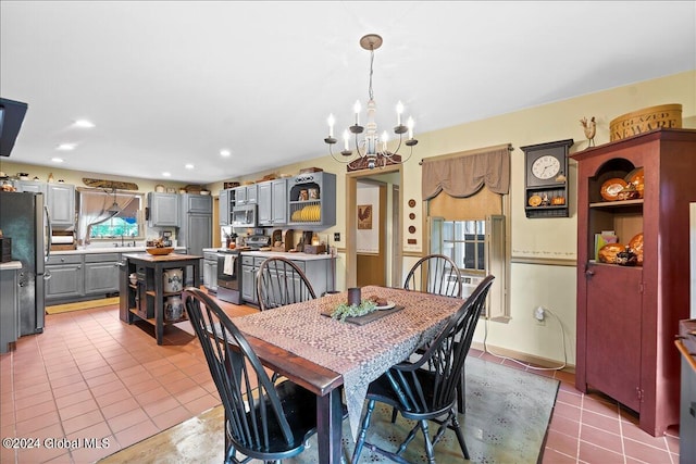 tiled dining room featuring sink and an inviting chandelier