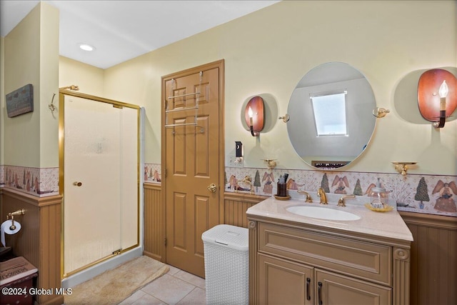 bathroom with tile patterned floors, vanity, a shower with shower door, and a skylight