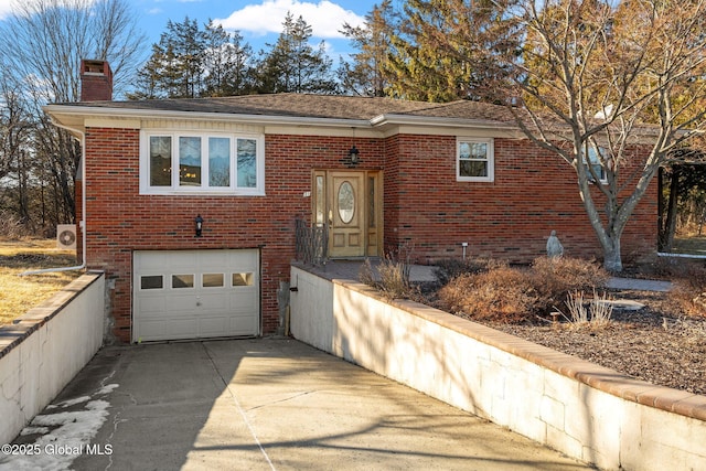 view of front of property featuring a garage, brick siding, driveway, and a chimney