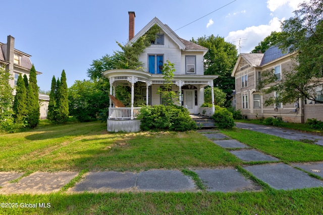 view of front of house with covered porch and a front yard