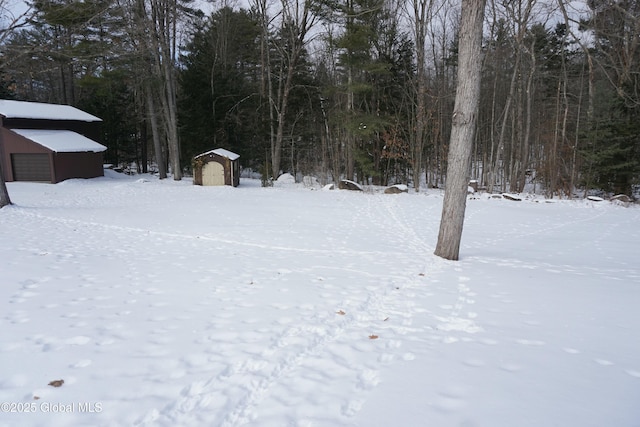 yard covered in snow featuring a shed