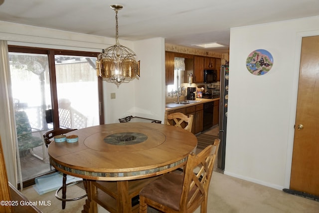 carpeted dining space featuring sink, a wealth of natural light, and a notable chandelier