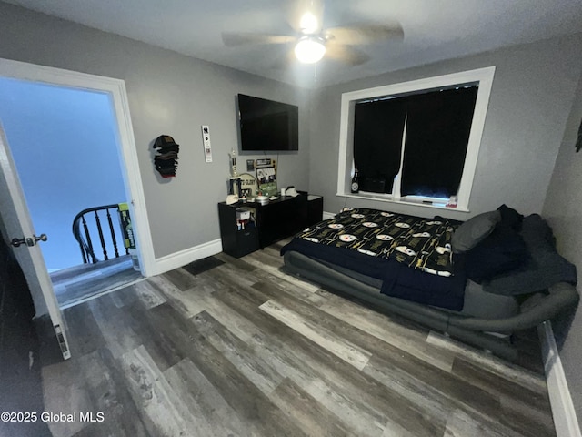 bedroom with dark hardwood / wood-style flooring and ceiling fan