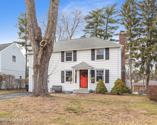 colonial home with a front lawn