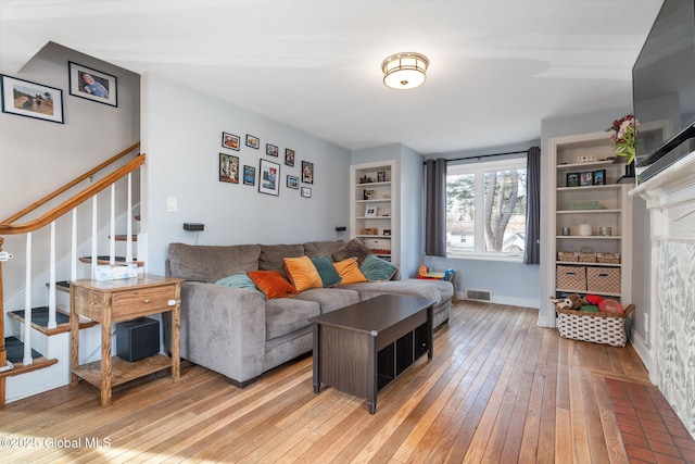 living room featuring hardwood / wood-style floors and built in features