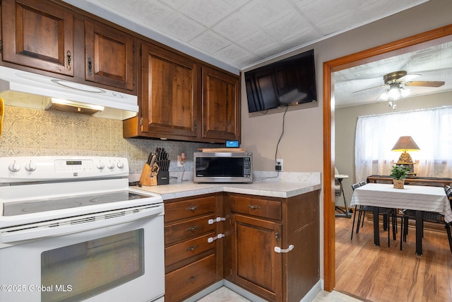 kitchen with ceiling fan, tasteful backsplash, light hardwood / wood-style flooring, and white range with electric stovetop