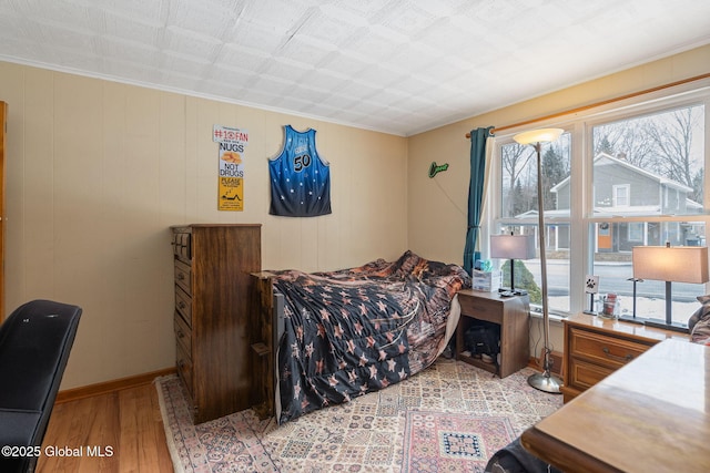 bedroom with light wood-type flooring and ornamental molding