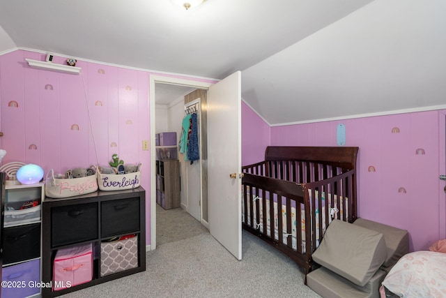 carpeted bedroom featuring wooden walls, a nursery area, and vaulted ceiling