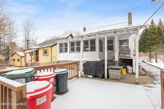 snow covered rear of property with a wooden deck