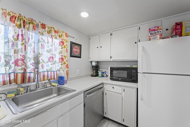 kitchen with stainless steel dishwasher, white refrigerator, white cabinets, and sink