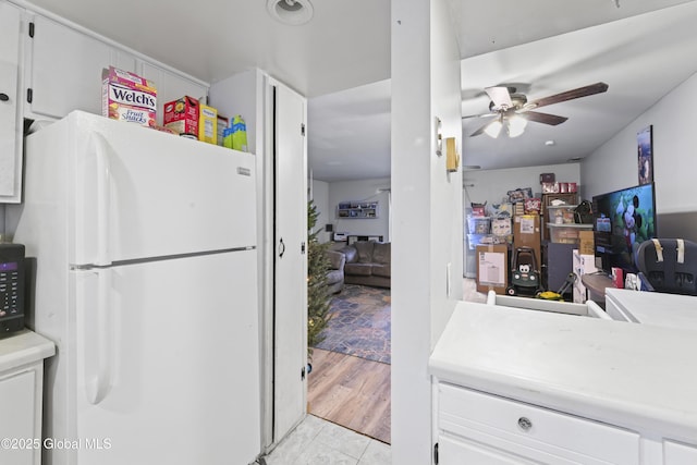 kitchen with white cabinets, ceiling fan, white fridge, and light tile patterned floors