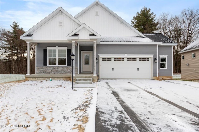 view of front of property featuring a garage, stone siding, and board and batten siding